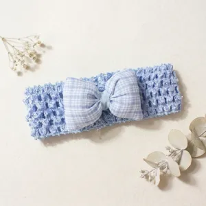 Close-up of blue hollow knitted baby headband featuring a cute plaid bow for sweet styling.