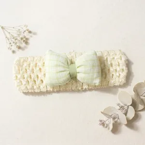 Close-up detail of the cute baby headband with green plaid bow and soft hollow knit.