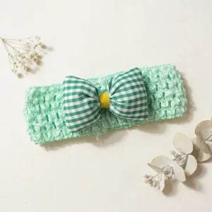 Mint green crochet baby headband with green checkered bow, cute accessory for babies.