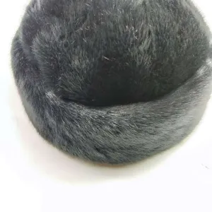 Gros plan d'un bonnet d'hiver chaud en fausse fourrure noire, texture peluche douce.