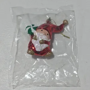 Close-up of Christmas gnome hanging ornament, red electroplated surface with sparkling glitter.
