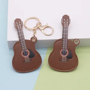 Detail view of creative PU leather guitar keychain, cute bag charm and car key ring accessory.