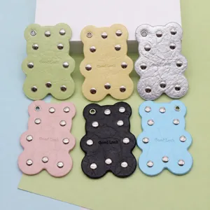 Cute leather bear bag charm with metal rivets, colorful keychain accessory, size 8x6cm.