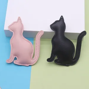 PU leather cat keychain detail view, minimalist bag pendant in pink and black colors.