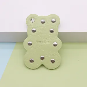 Green leather bear keychain with metal rivets, cute cartoon bag pendant charm accessory.