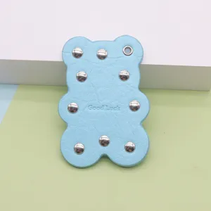 Cute leather bear keychain with metal rivets, stylish bag charm and fashion accessory.