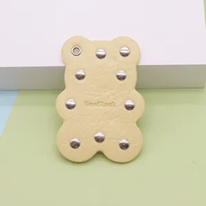 Cute yellow bear shaped leather keychain pendant with metal rivets bag charm accessory.