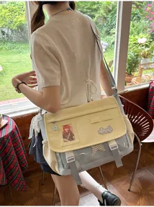 Detailed view of the color-blocking messenger ita bag with clear window in scenic room.