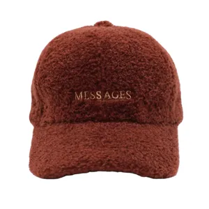 Détail de gros plan de la casquette de baseball en polaire marron avec broderie de lettres.
