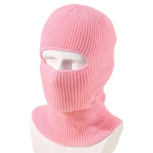 Primo piano sul dettaglio del passamontagna in maglia rosa, consistenza morbida per inverno.