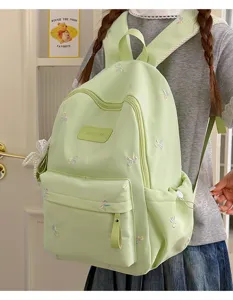 Light green sweet school backpack with colorful bow embroidery, detailed view for students.