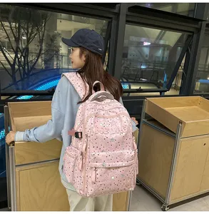 Detailed view of the pink star pattern backpack worn by a model, showing front embroidery.
