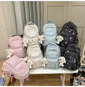 Detailed view of trendy star pattern school backpacks with cute bunny pendants in multiple colors.
