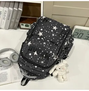 Detailed view of black star patterned casual backpack with cute bunny pendant for students.