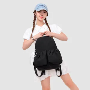 Mochila informal de lona negra con bolsillos frontales con cordón y detalles de encaje.