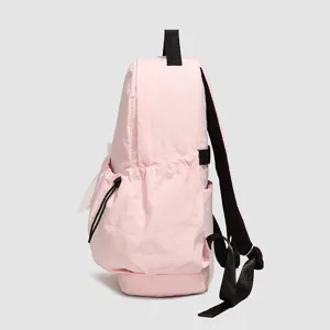 Vista detallada de la elegante mochila informal rosa con bolsillo lateral y correas negras.
