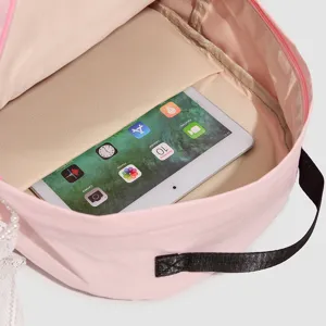 Detalle compartimento interior mochila rosa mostrando capacidad tablet y encaje elegante.