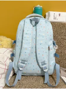 Close-up detail of the light blue backpack back straps, featuring cute cartoon patterns and side pocket.