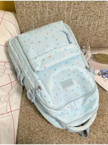 Detailed view of light blue cute backpack featuring colorful stars and musical notes print.