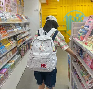 Vue détaillée d'un sac à dos gris décontracté avec motif d'étoiles dans un magasin.