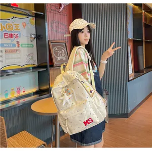 Sac à dos en toile jaune crème avec motif d'étoiles et pendentif pour les voyages et l'usage quotidien.