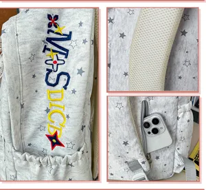 Sac à dos gris à motif d'étoiles, vue détaillée avec broderie et poche latérale.