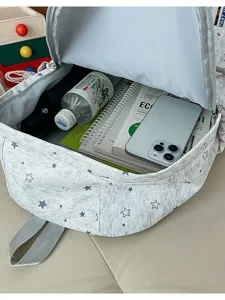 Sac à dos gris avec motif d'étoiles et grand espace intérieur pour les voyages quotidiens.