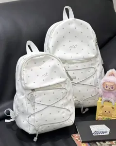 Detail view of Korean style white polka dot backpacks featuring front pockets and elastic cord.