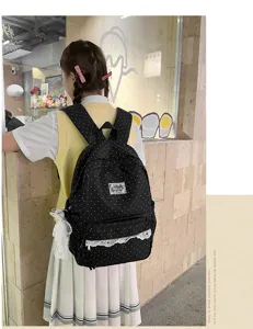 Close-up detail of black polka dot backpack with sweet lace trim and cute bow charm.