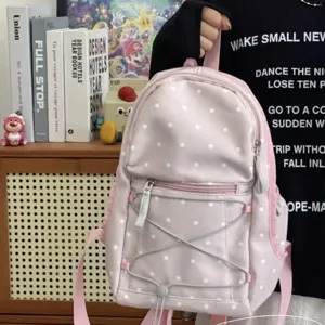 Pink polka dot backpack detail showing cute design, soft fabric, and convenient front elastic cord.