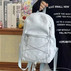 Detailed view of light blue polka dot backpack with front zipper pocket and drawstring style.