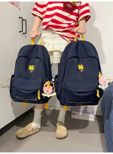 Navy blue canvas backpack with yellow four-leaf clover embroidery and cute plush pendant.