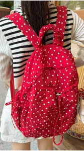 Detailaufnahme des roten Pünktchen-Rucksacks mit süßen Rüschen und Kordelzugtaschen.