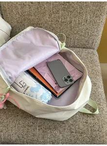 Detail shot showing the spacious interior capacity of a casual canvas backpack filled with books.