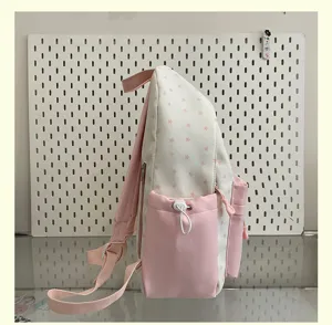 Side detail view of the pink and white star print backpack showcasing side pocket and drawstring.
