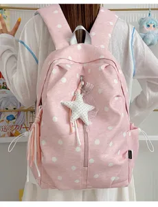 Gedetailleerd uitzicht op roze rugzak met stippen, sterhangers, zachte stof, casual stijl.