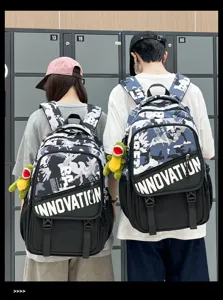 Sac à dos camouflage tendance pour étudiants avec imprimé color-block et joli pendentif dinosaure.