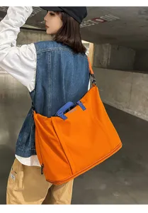Grande borsa da viaggio arancione con manici blu e design espandibile per donne e fitness.