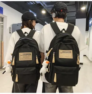 Casual black canvas backpack for students, multi-compartment travel daypack with duck pendant.