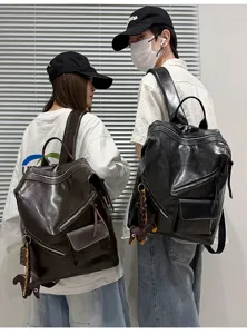 Detailed view of retro leather backpack with multi zippers and cute keychain in daily use.