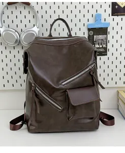 Dark brown leather backpack detail showcasing vintage motorcycle style and diagonal zippers.