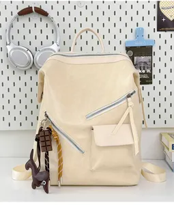 Close-up view of a beige retro casual motorcycle style backpack featuring diagonal zipper pockets.