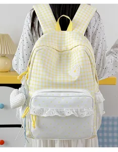 Detailed view of sweet yellow gingham backpack with white polka dot pocket and cute lace ruffles.
