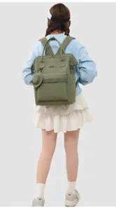 Green wide-mouth canvas backpack with dual top handles, front pocket and small coin purse.
