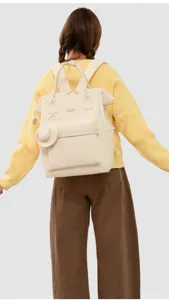Beige canvas diaper backpack with matching small pouch, stylish and practical for moms.
