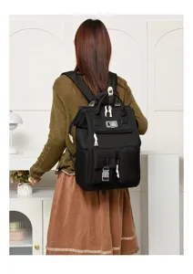Detailed view of black multi-pocket diaper backpack with shoulder straps and handy compartments.