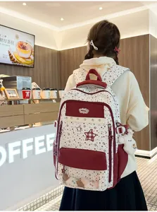 Detail view of the sweet color-blocked school backpack with clear front pocket and star prints.