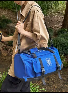 Vue détaillée du grand sac de voyage bleu en plein air montrant un tissu durable.