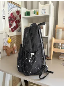 Detailed side view of black star print school backpack with side pockets and straps.