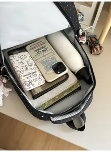 Classic black polka dot backpack with spacious interior, perfect for school and daily travel.